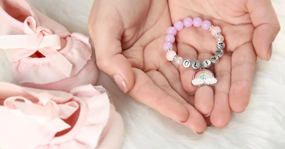 Mother’s Day personalized bracelet with baby name Olivia in a mother’s hands, meaningful gift idea for new moms