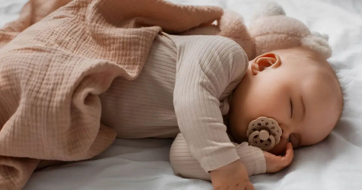 Baby Sleep Schedule: cute baby cuddling a stuffed animal, representing healthy sleep routines and gentle bedtime habits for tired moms