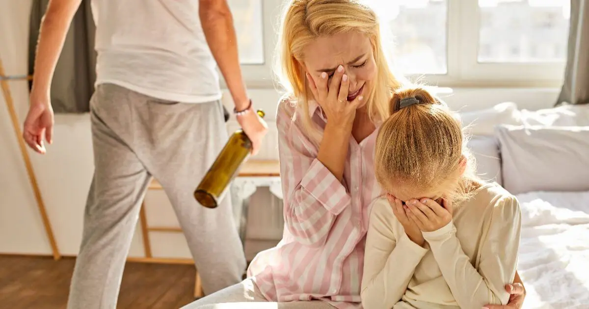 Mental load and emotional burnout as an overwhelmed mother comforts her child while feeling exhausted, highlighting the emotional weight of carrying invisible family responsibilities.