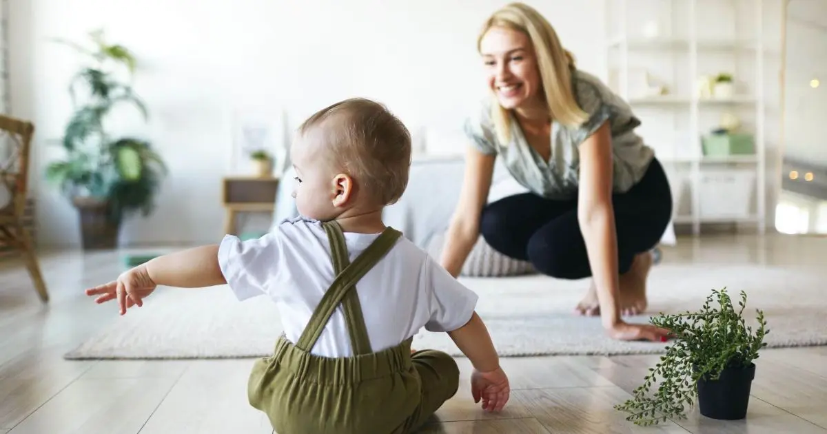 Baby milestones 7 to 12 months: What to Expect in the Next Big Stage Mother smiling at her baby during floor play at home, capturing a gentle moment of connection often shaped by mom guilt and expectations.