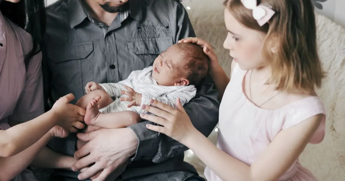 Baby Visitors meeting newborn baby with family gathered around