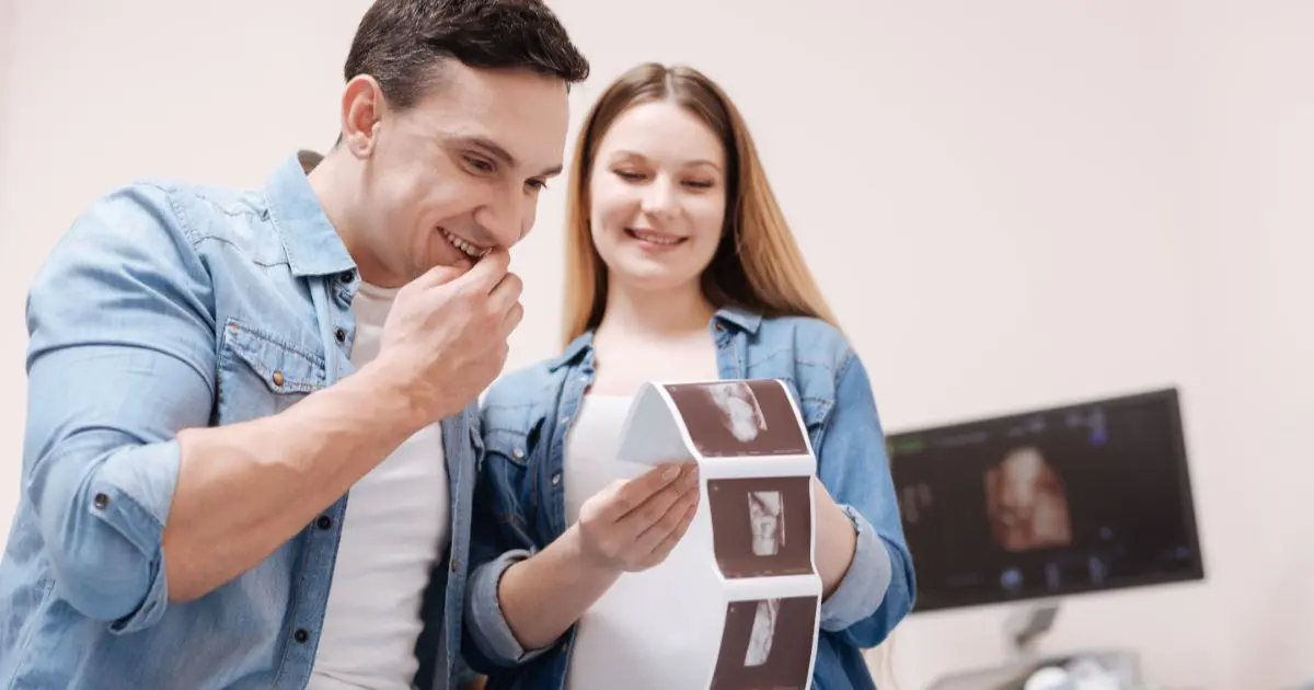 5 Early Pregnancy Symptoms You Shouldn’t Ignore couple looking at ultrasound scan in clinic emotional moment male fertility and pregnancy