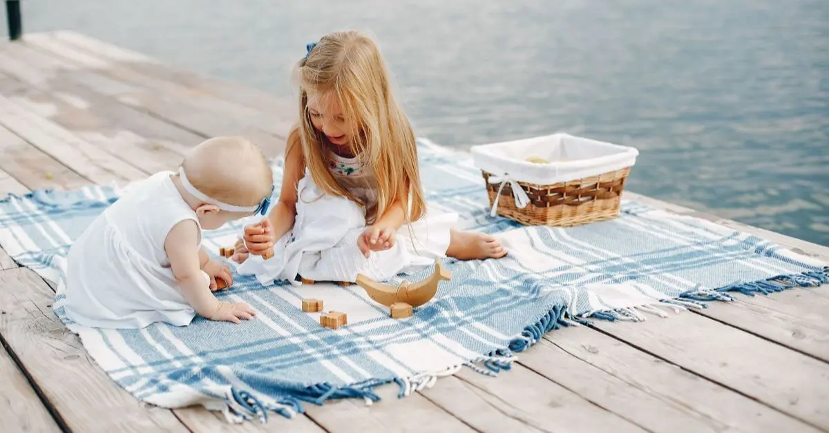 Little girl near a lake during a peaceful vacationing with a baby family trip