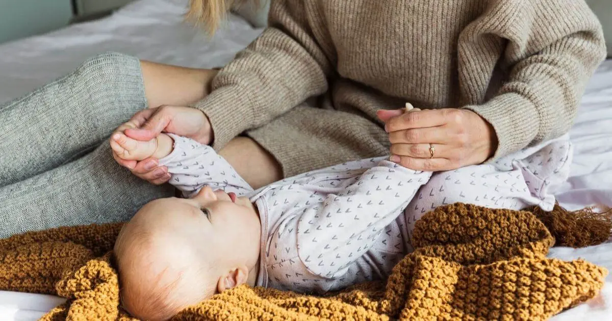 Gentle Parenting in Real Life – midsection of a woman sitting on a sofa at home, reflecting on calm parenting moments, presence, and emotional balance.