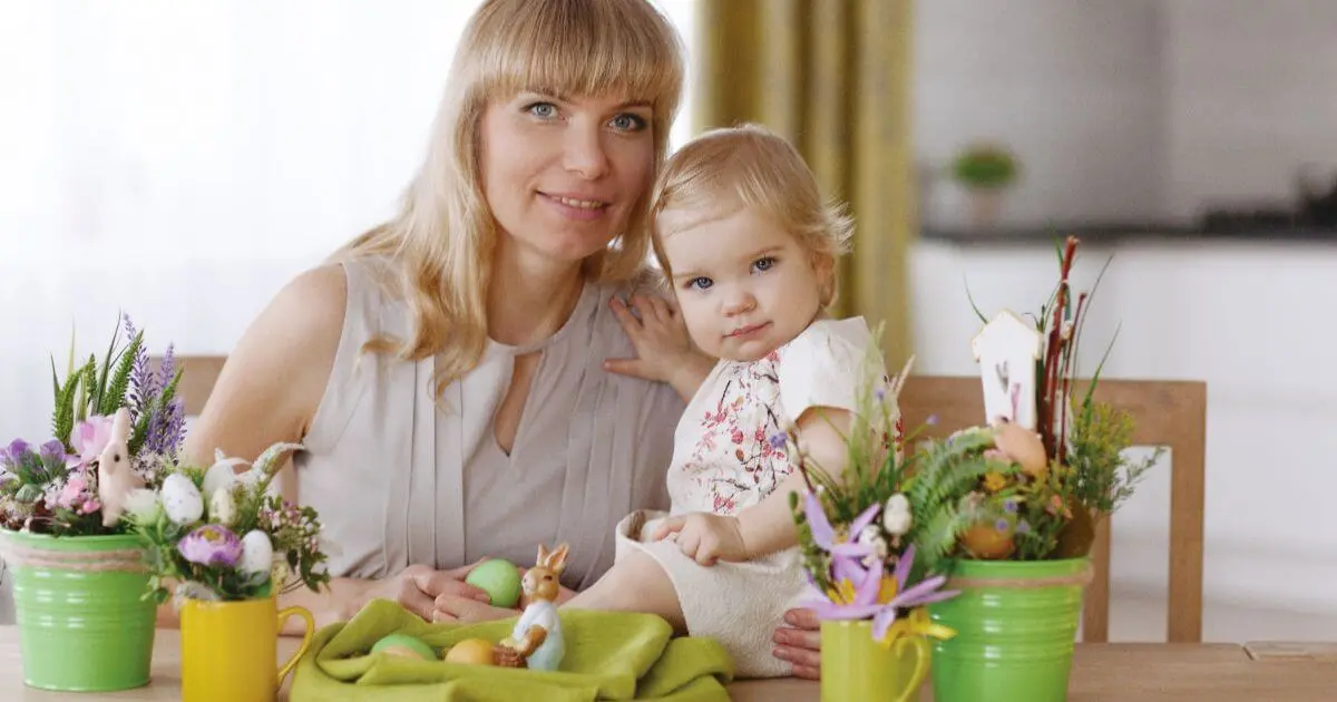 mom and kids sitting at dinner table with colorful easter eggs during easter preparation