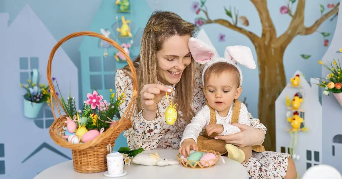 mom and daughter painting easter eggs together in bright home during easter preparation