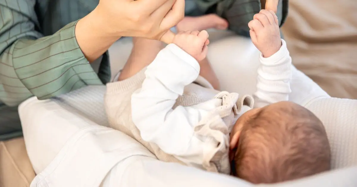 Newborn Care: mother playing gently with her newborn baby during a daily care routine