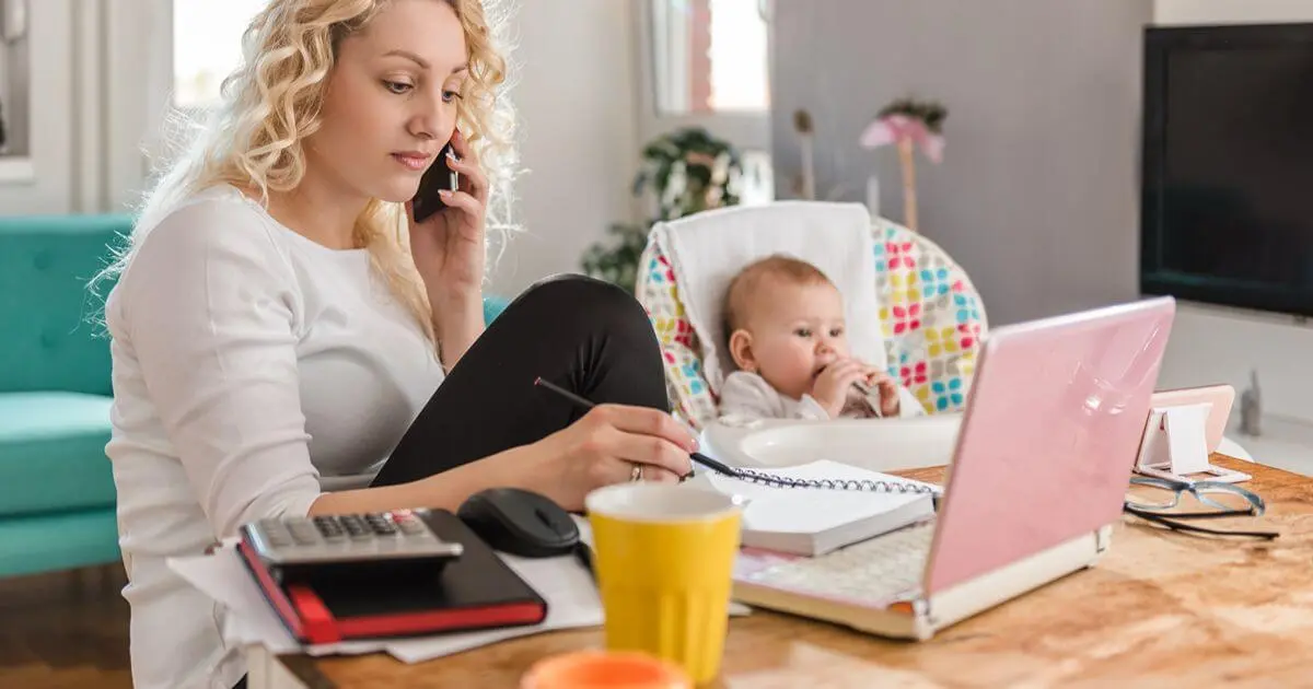 Returning to Work: Working mom taking a business call while caring for her baby during her return to work after maternity leave.