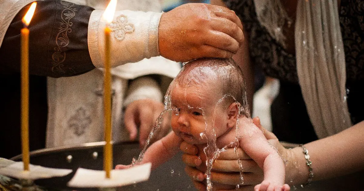 Baptism moment with holy water being poured over newborn in church ceremony
