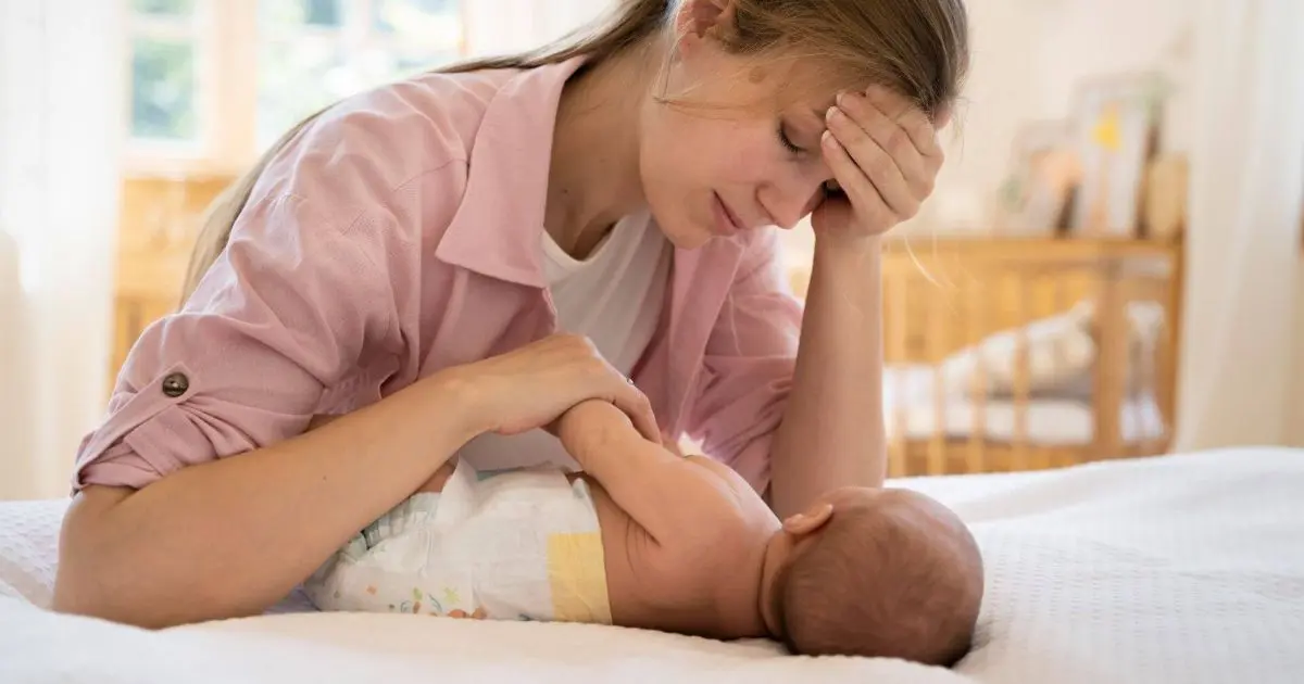 Infant Colic: tired mom comforting crying infant
