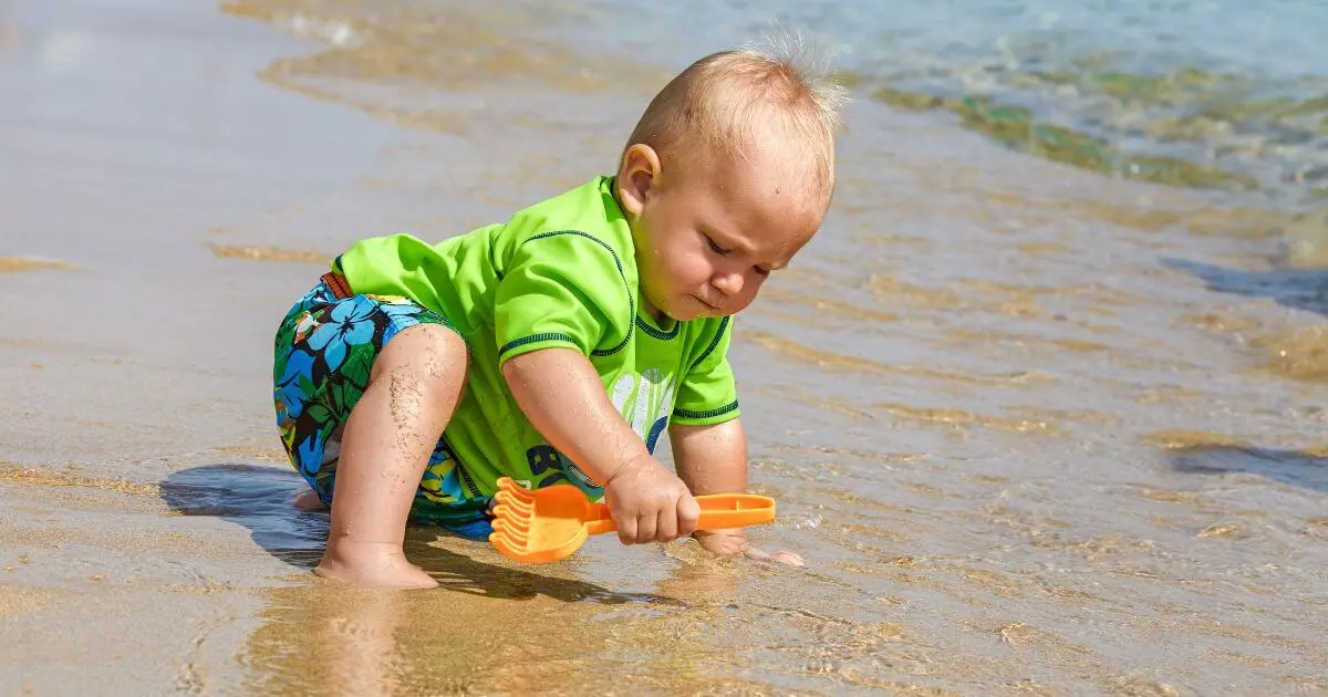 What to Watch for During Summer? Sensory Activities Toddlers and Babies Love (0–12 Months) Baby exploring sand and water at the beach during summer sensory play, supporting early learning through sensory activities toddlers and babies naturally enjoy outdoors.