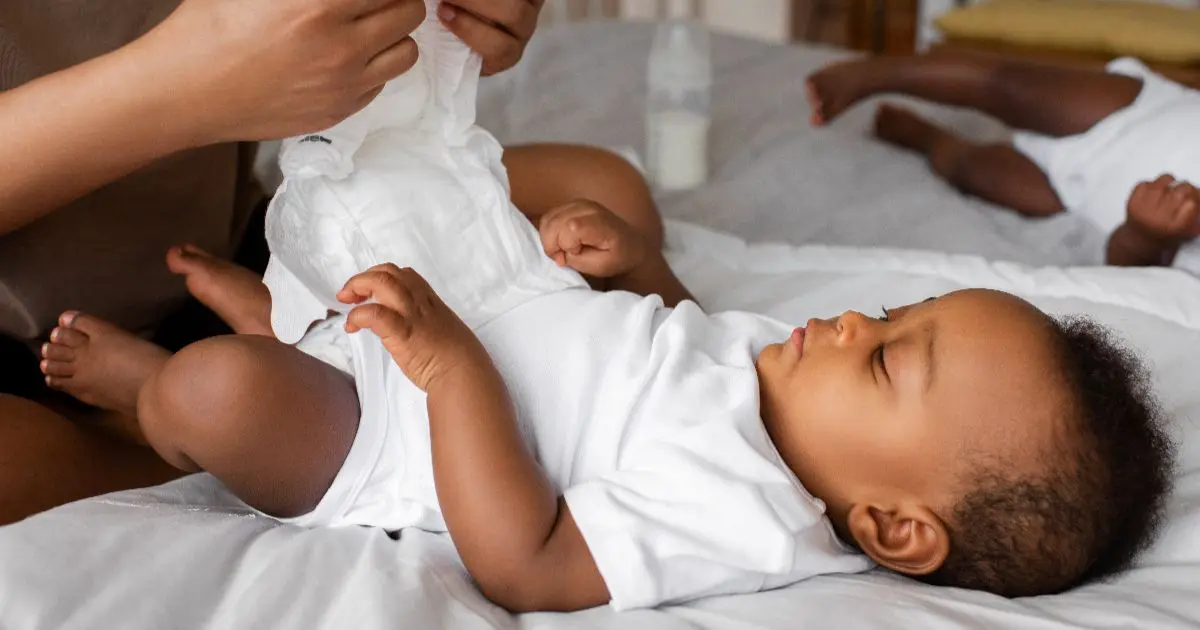 Baby care routine with a mother changing her newborn baby’s diaper during a calm daily care moment at home.
