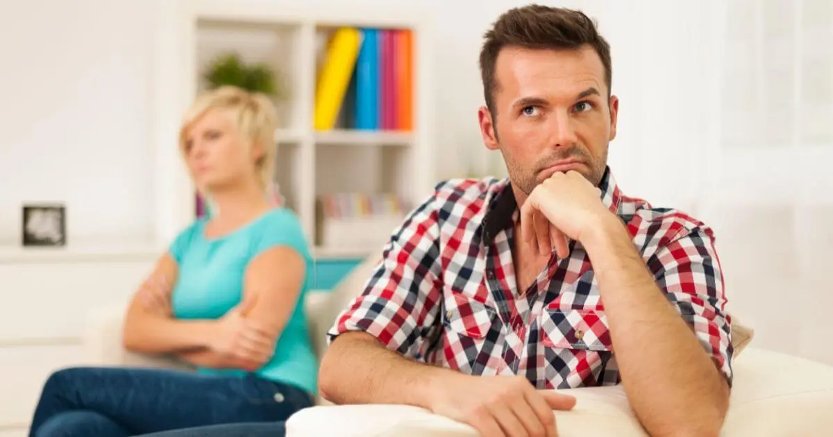 unhappy couple sitting apart in silence, emotional disconnection in relationship after baby