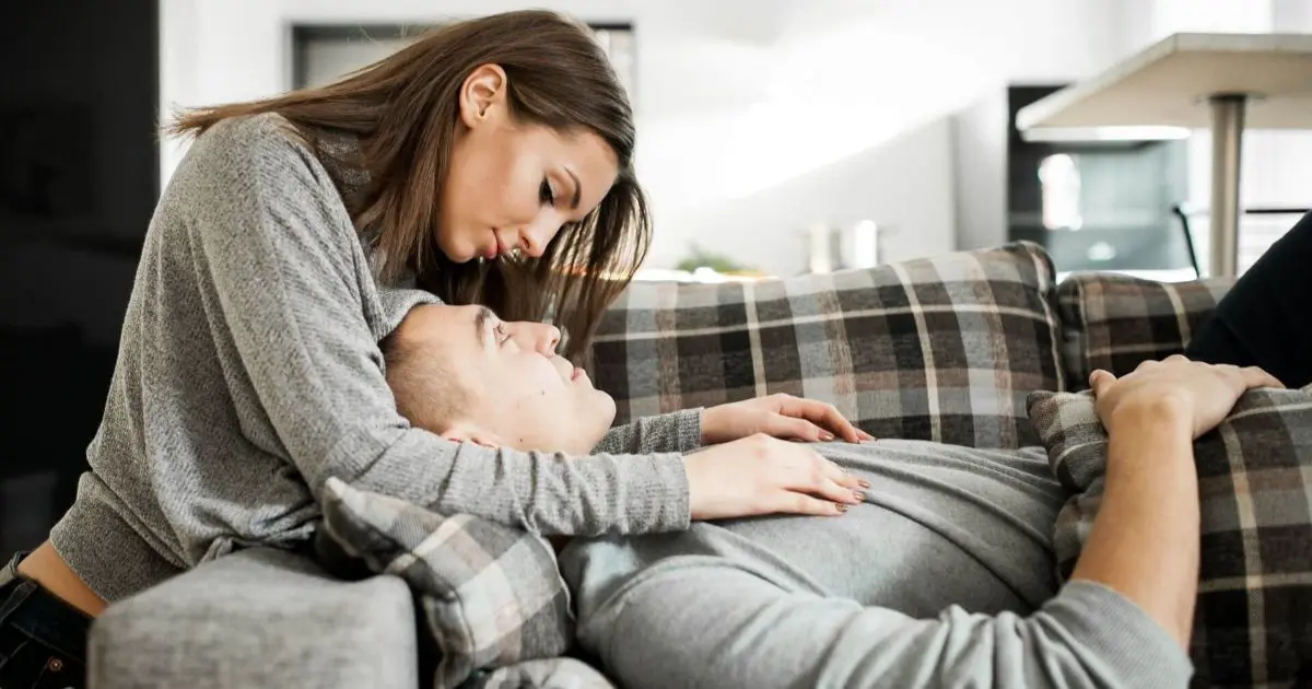 Young couple sitting together on a sofa at home, sharing a quiet moment