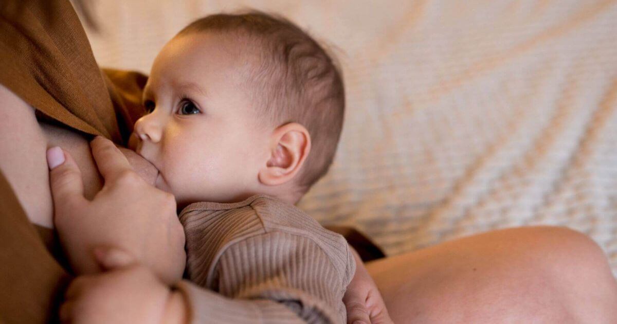 The Truth About Breastfeeding: The Pain, the Tears, and the Tiny Victories young-woman-breastfeeding-her-cute-baby in a quiet, intimate moment showing real motherhood and emotional connection